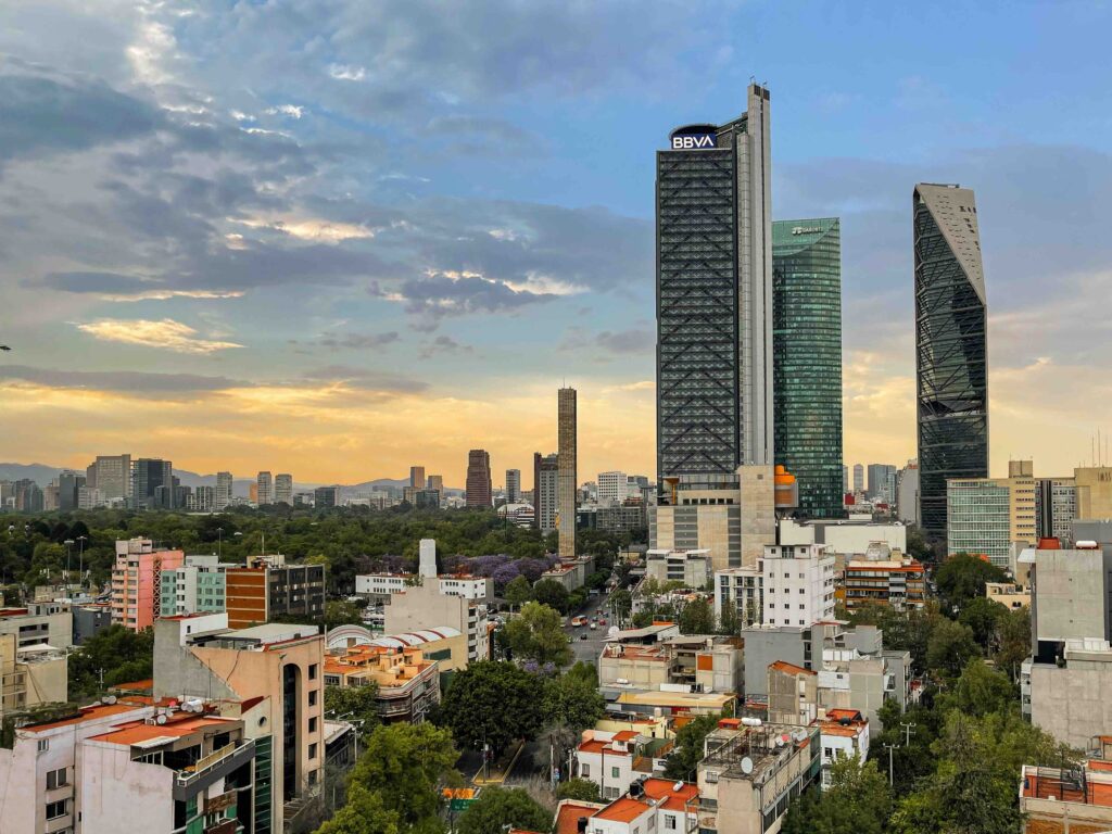Sprawling Mexico City skyline at sunset with Reforma skyscrapers and dense buildings reaching the horizon
