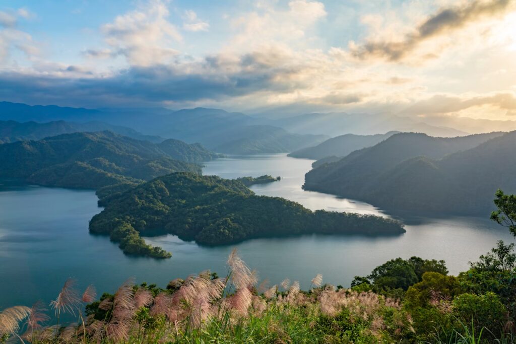 Taiwan’s Cultural Riches and Natural Wonders: A Journey Through the Island Misty mountain lake with forested islands and sunrays at dawn, Taiwan