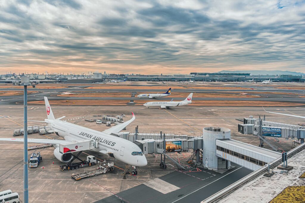 Japan Airlines and Skymark jets at a Tokyo airport, arriving on a budget flight to Japan