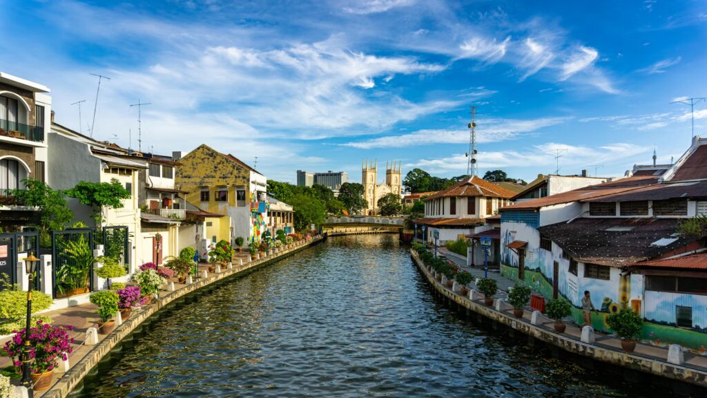 First Time Visiting Malaysia: Why the Country Can Feel Quiet at First Colorful heritage shophouses along the Malacca River under blue sky, first time visiting Malaysia guide