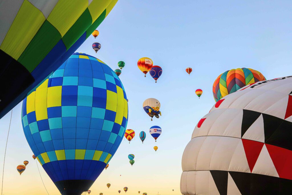 Colorful hot air balloons rising against a bright sky, the wonder of first-time travel