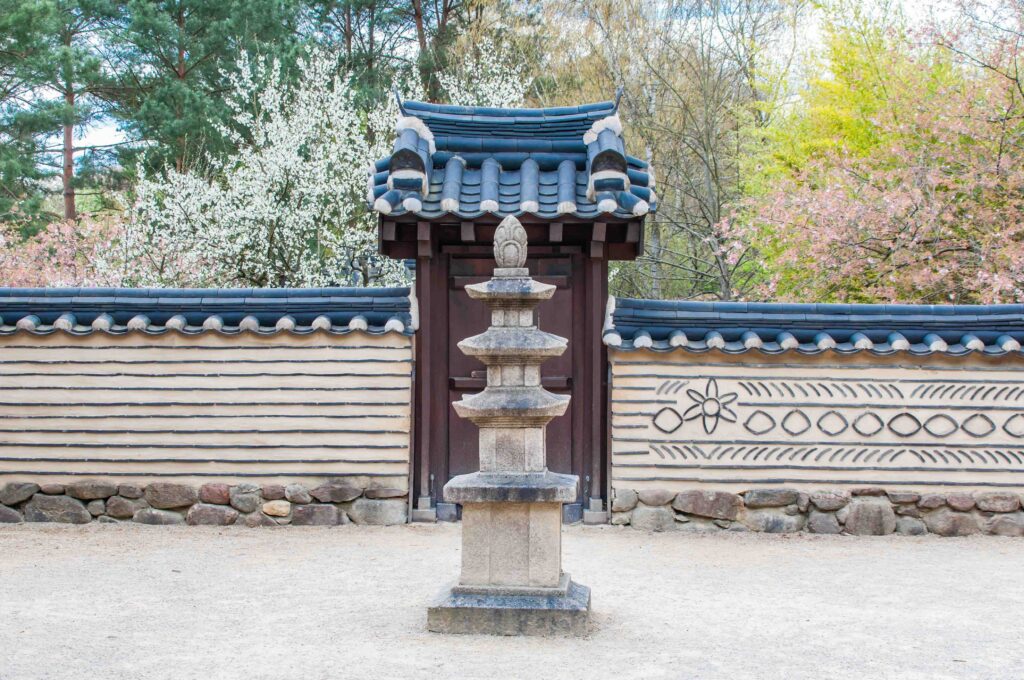 Hanok gate with stone pagoda and spring blossoms in South Korea, ideal trip duration guide