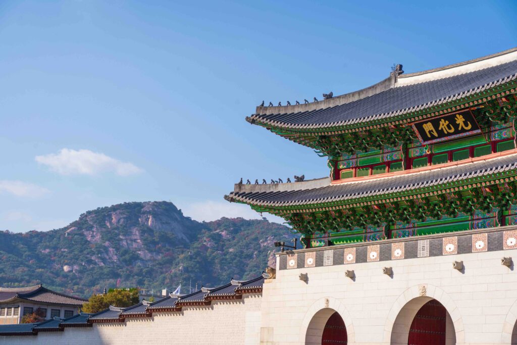Gwanghwamun Gate of Gyeongbokgung Palace below Bugaksan mountain under a clear blue sky in Seoul
