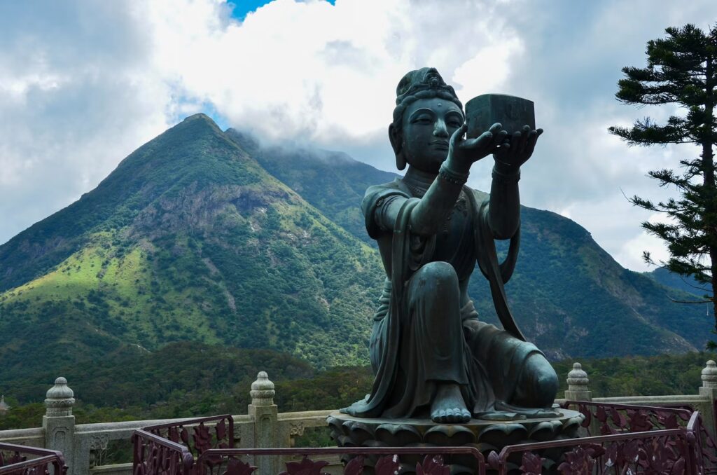 Bronze offering statue with green Lantau hills behind at Ngong Ping, experiencing China in Hong Kong