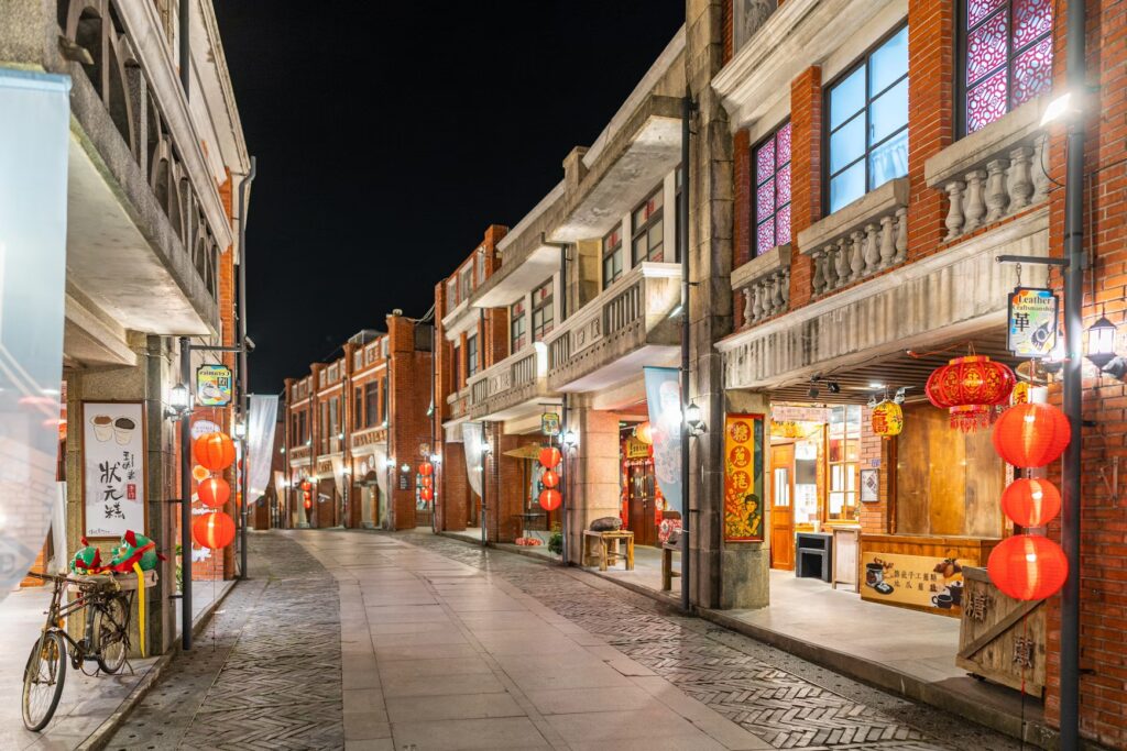 Visiting Taiwan: Why the Country Often Feels Better After the First Few Days Red lanterns lighting a historic brick shophouse street at night in Taiwan.