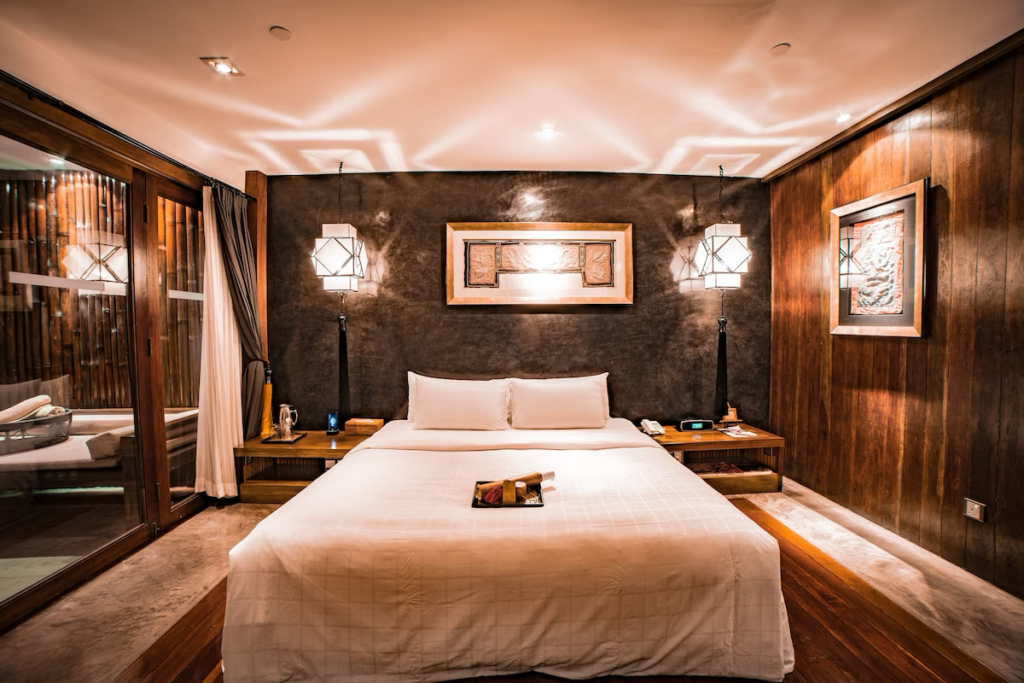 A tranquil bedroom suite featuring dark wood walls and a relaxing ambiance at Villa Samadhi Kuala Lumpur.