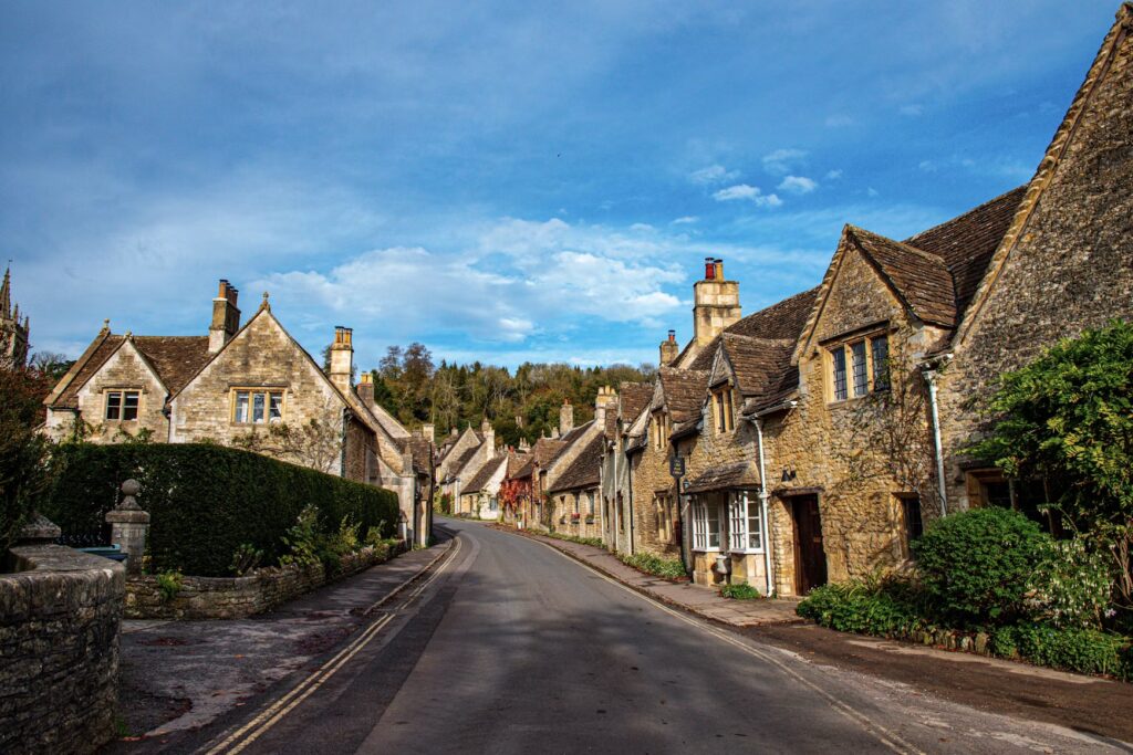 Best Time to Visit the UK: A Complete Seasonal Guide for First-Time Travelers Honey-colored stone cottages along a curving lane in the Cotswolds under blue sky, England