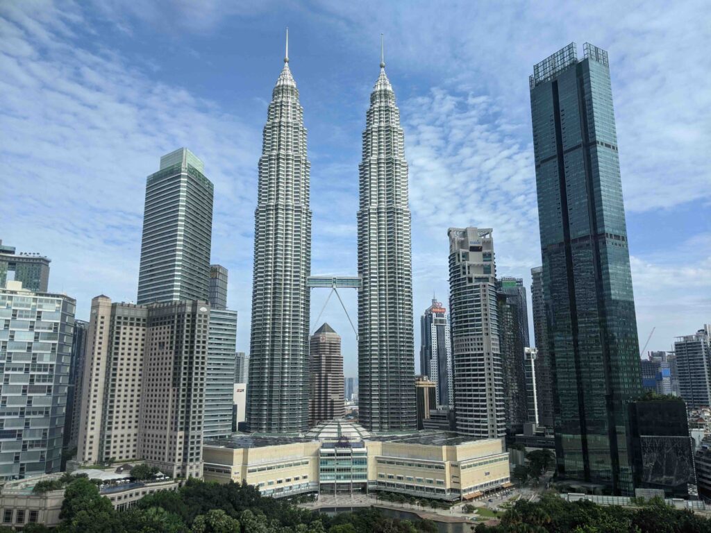 Flying from Bali to Kuala Lumpur: What to Expect on a Quick and Easy Flight Between Two Popular Destinations The iconic Petronas Twin Towers rising prominently above the modern city skyline of Kuala Lumpur.