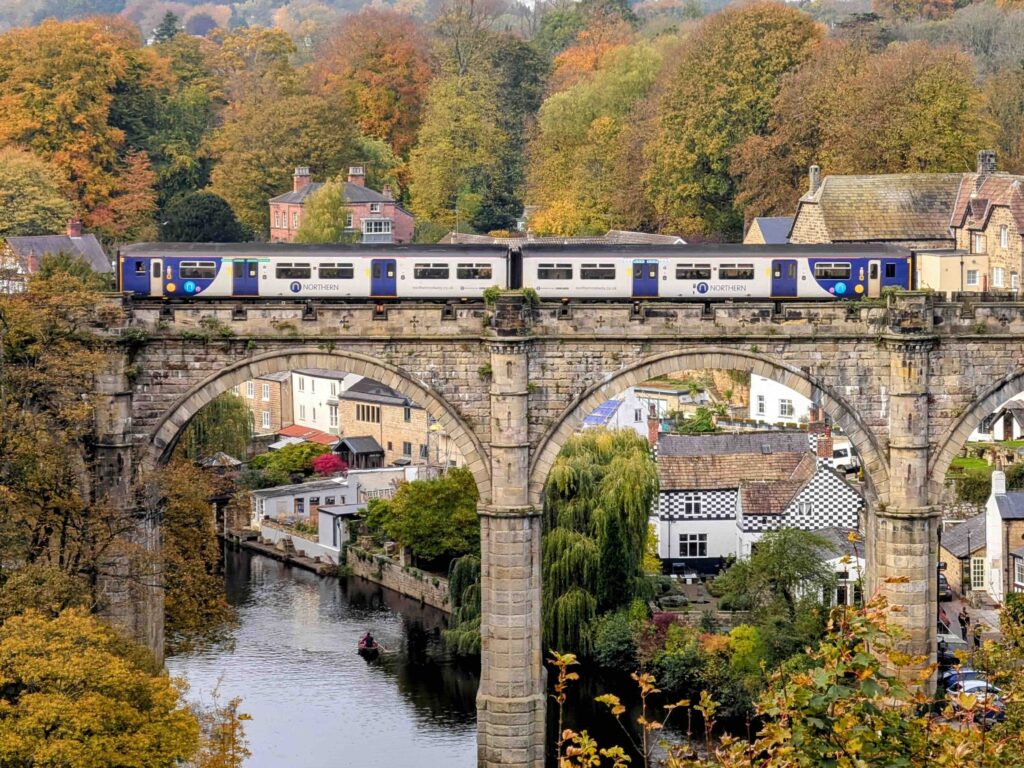 Best Cities to Visit in the UK by Train: Explore Beyond London’s Limits Train crossing Knaresborough Viaduct over the River Nidd in autumn, Yorkshire, UK