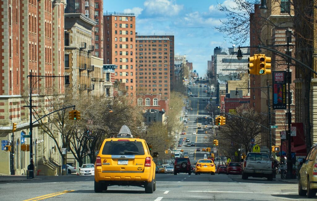How to Get Around the U.S.: Essential Transportation Tips for First-Time Travelers Yellow taxi cab driving down a New York City avenue, US transportation tips for first-time travelers
