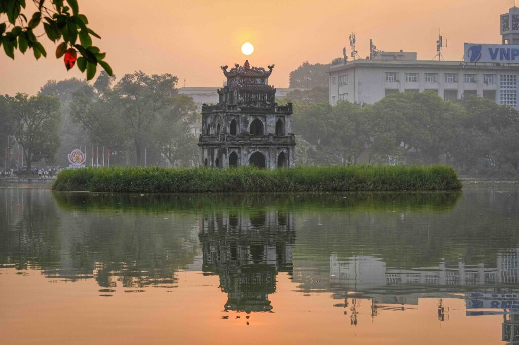 Where to Stay in Hanoi: Hotels with Walkability, Context, and Tranquil Atmosphere Turtle Tower on Hoan Kiem Lake at sunset, where to stay in Hanoi near historical hotels.