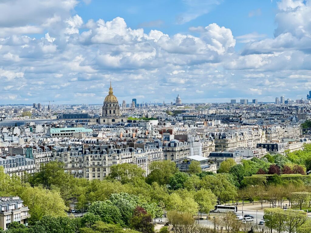 21 Fun Things to Do in Paris (Beyond the Boring Museums) Panoramic view of Paris skyline featuring the golden dome of Les Invalides.