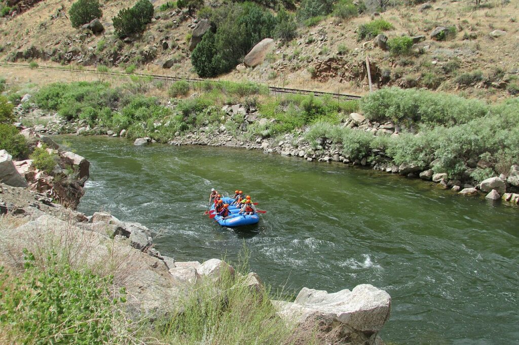 A blue raft full of people floating down the Arkansas River in Buena Vista. 