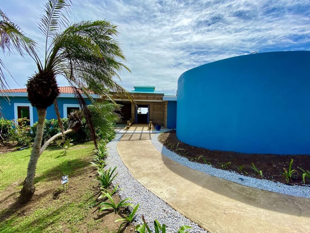 Bright blue exterior building and paved walkway at Blue Horizon Boutique Resort. 
