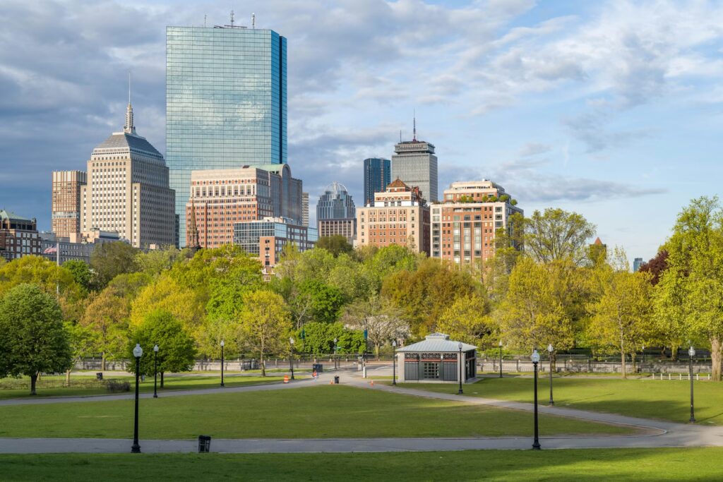 Boston city skyline rising above a lush green park, an ideal setting for fun vacations for kids