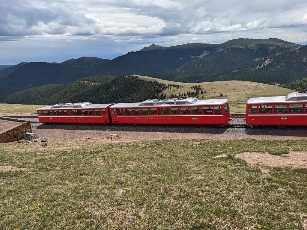 The red Broadmoor Manitou and Pikes Peak Cog Railway climbing the mountain. 
