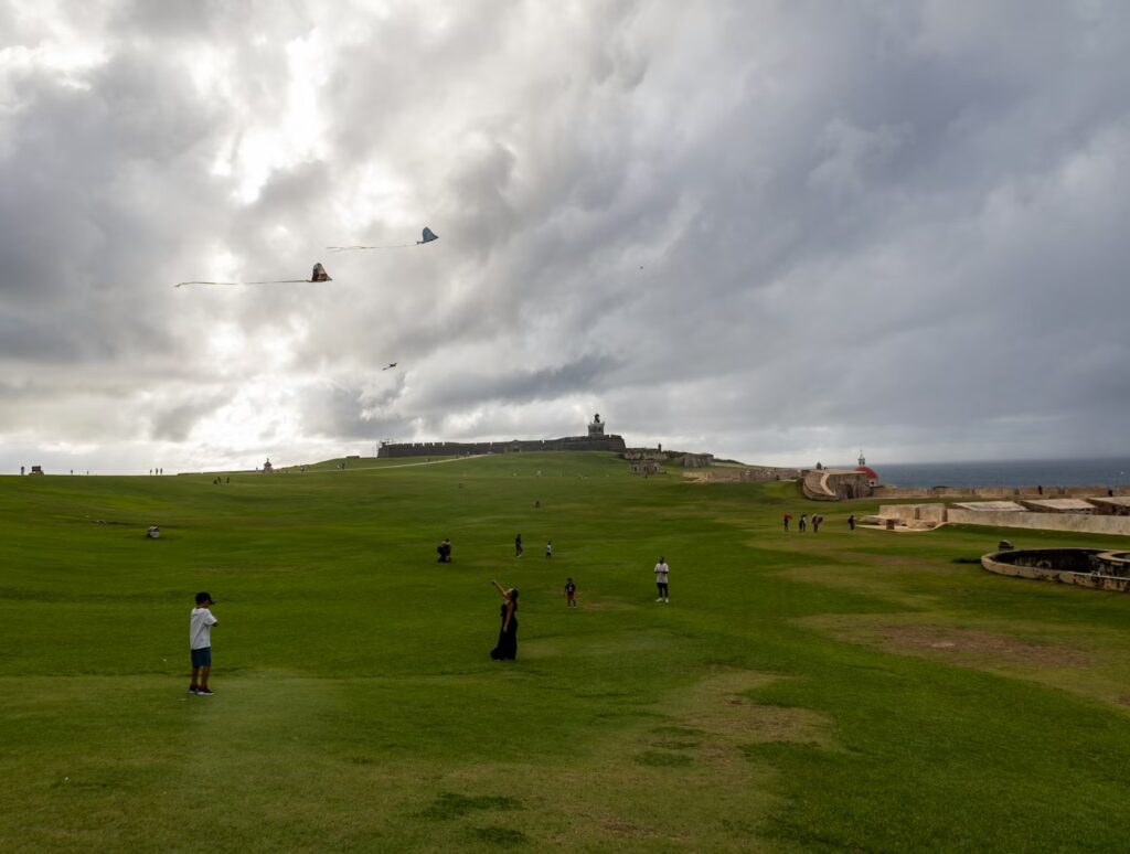 People flying kites on the lawn at El Morro, one of the best things to do in puerto rico. 