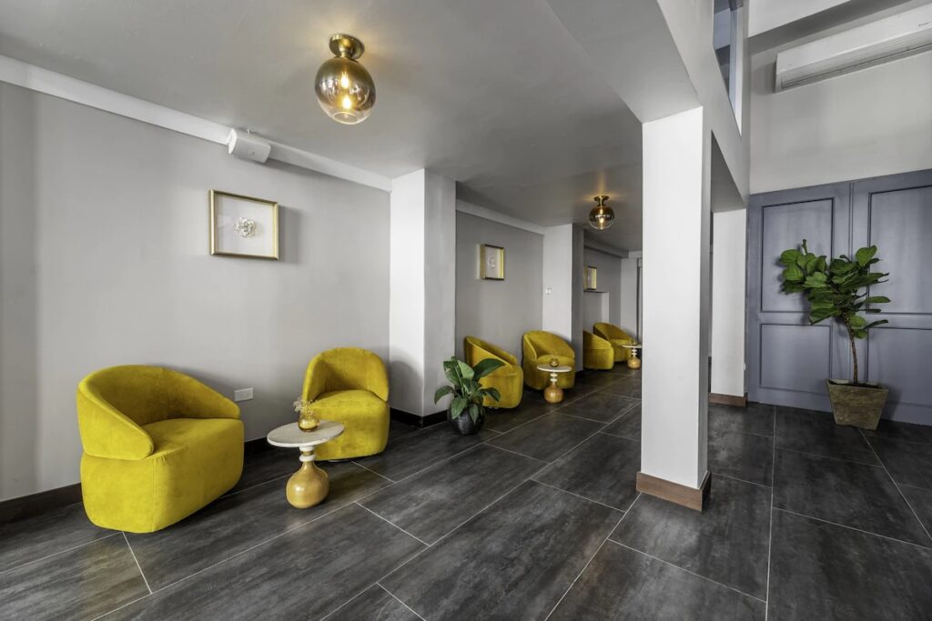 Modern lobby lounge with yellow velvet chairs at El Colonial, an adults-only choice among hotels in old san juan. 