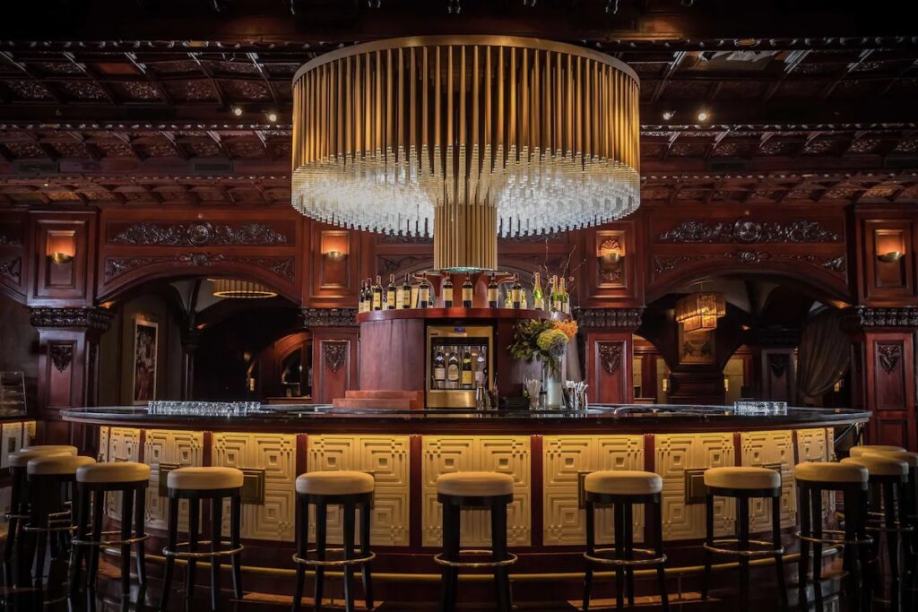 Grand oval bar featuring a massive crystal chandelier at Fairmont El San Juan 