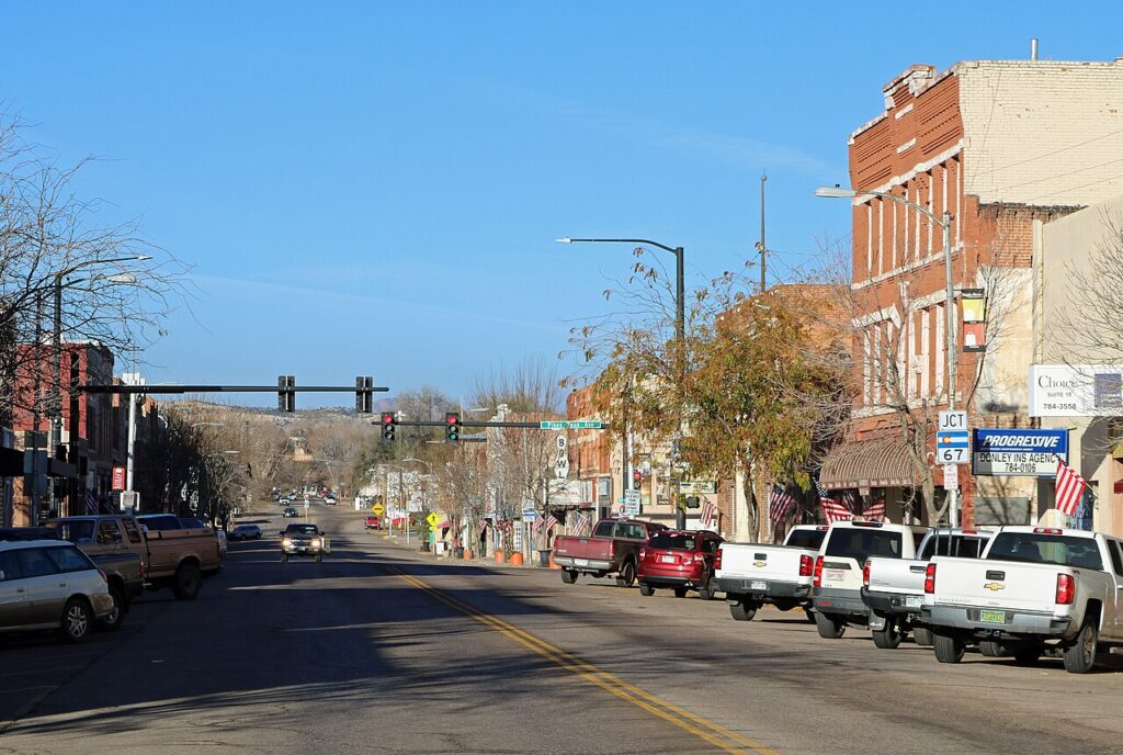 Main street in Florence lined with historic brick buildings and parked cars. 