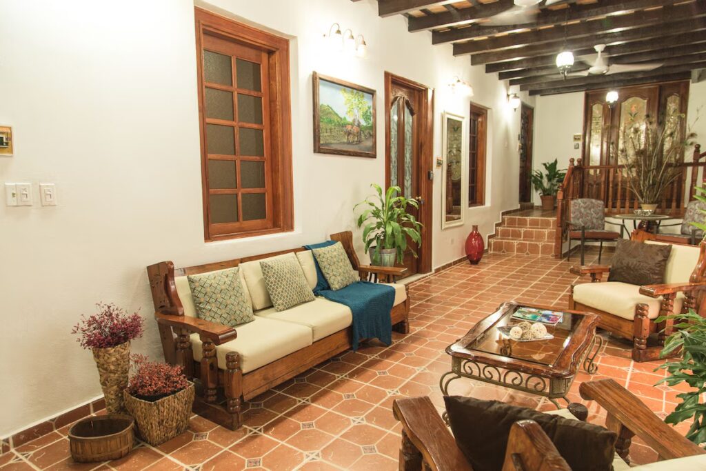 Comfortable indoor seating area with rustic wooden couches and tiled floor at Fortaleza Suites. 