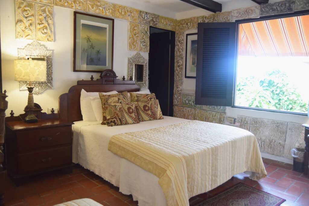 Rustic bedroom featuring vintage decor and a window looking out to the street at The Gallery Inn. 