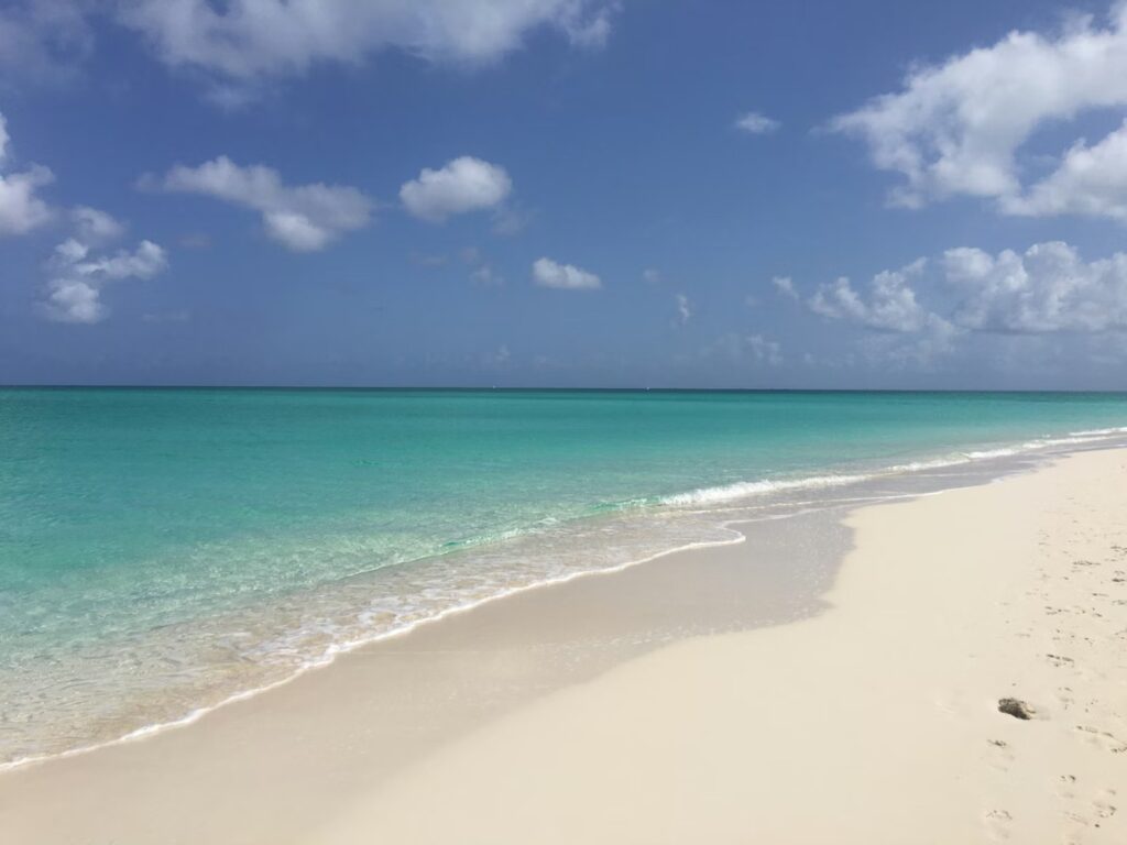 Crystal clear water gently laps the shore of Grace Bay Beach, Turks and Caicos, one of the best caribbean islands for families