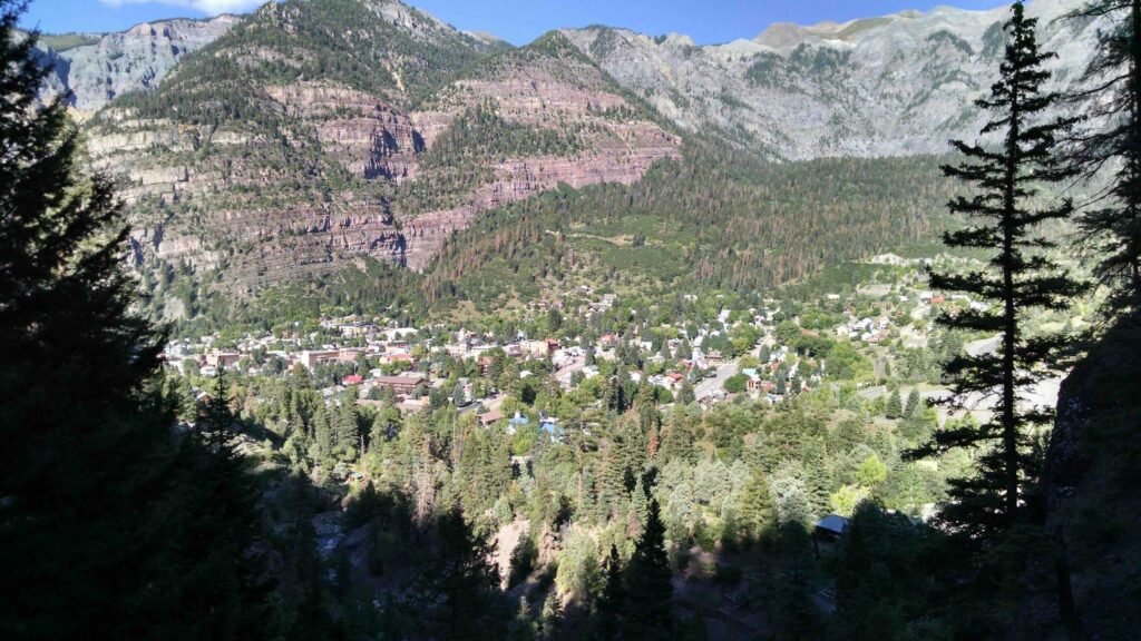 Looking down through pine trees into the small mountain valley town of Ouray. 