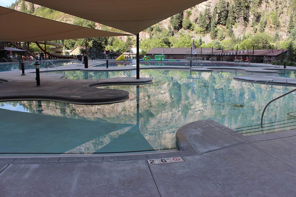 Large outdoor swimming pool at Ouray Hot Springs surrounded by mountains. 