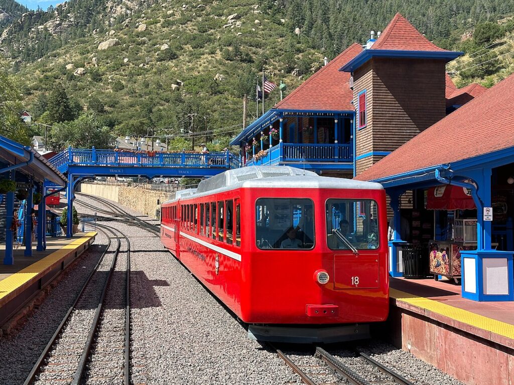 A red cog railway train parked at the mountain station platform. 