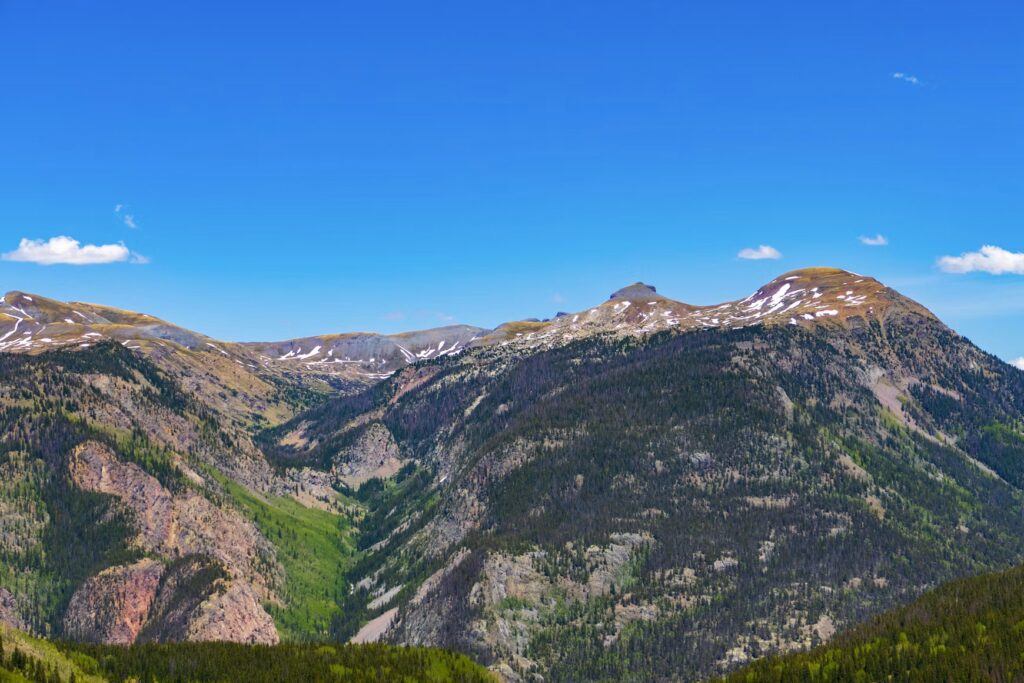 Wide view of the rugged San Juan Mountains under a bright blue sky. 
