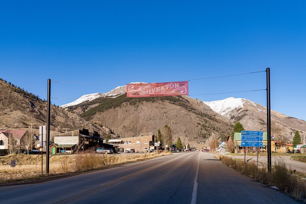 A large red welcome sign stretched across the road entering Silverton. 