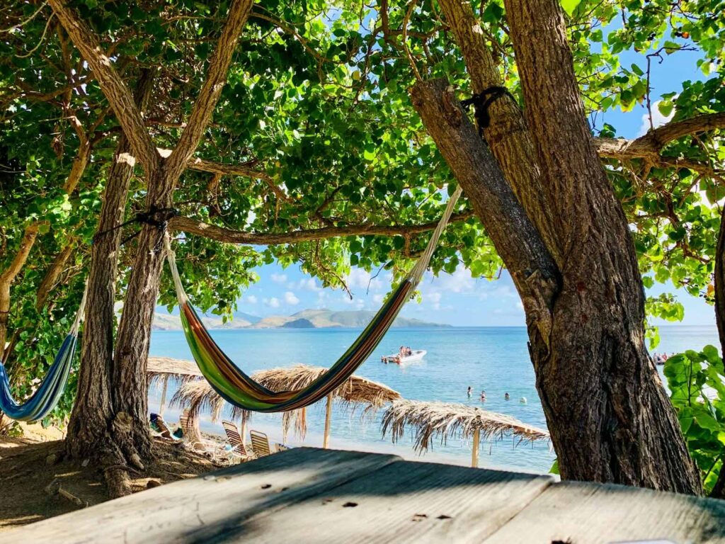 Relaxing in a beach hammock looking at the sea, perfect for a peaceful caribbean vacation with kids