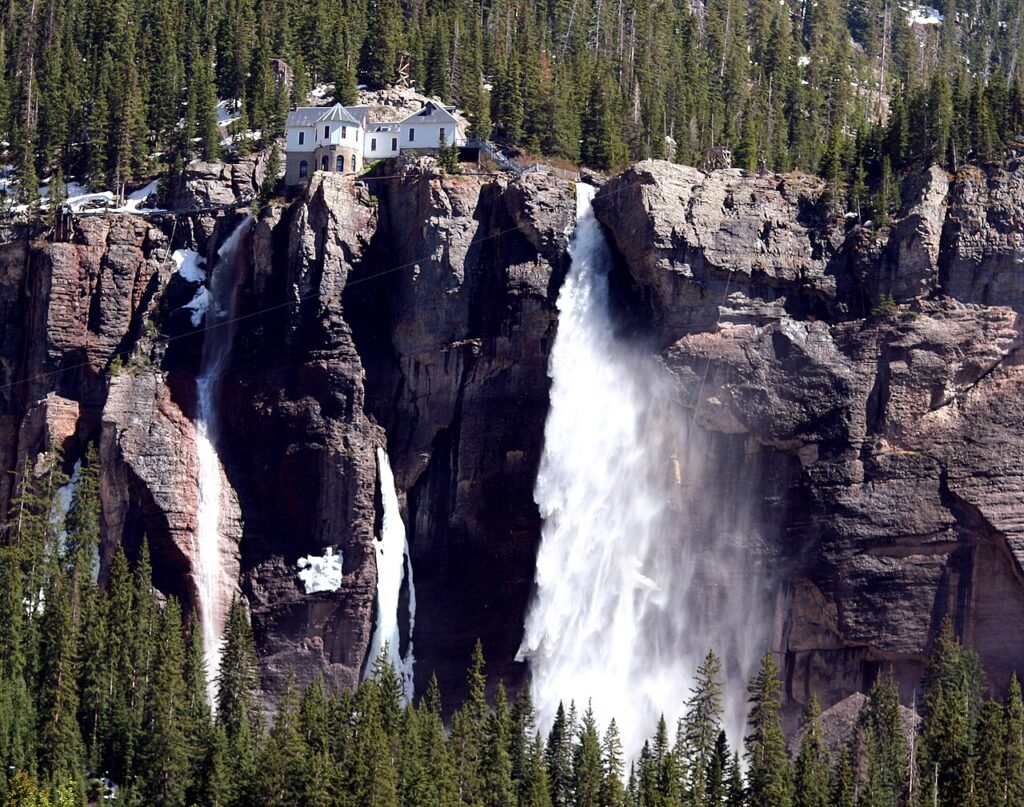 Bridal Veil Falls cascading down a sheer rocky cliff edge in Telluride. 