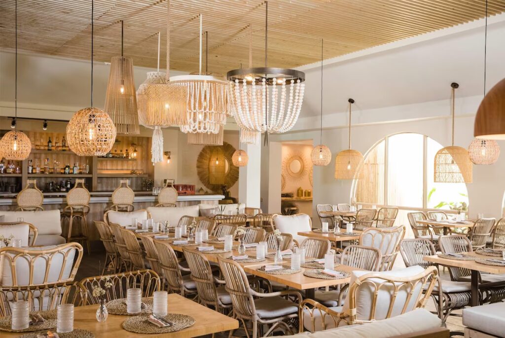 Stylish indoor restaurant with woven chairs, wooden tables, and beaded chandeliers 