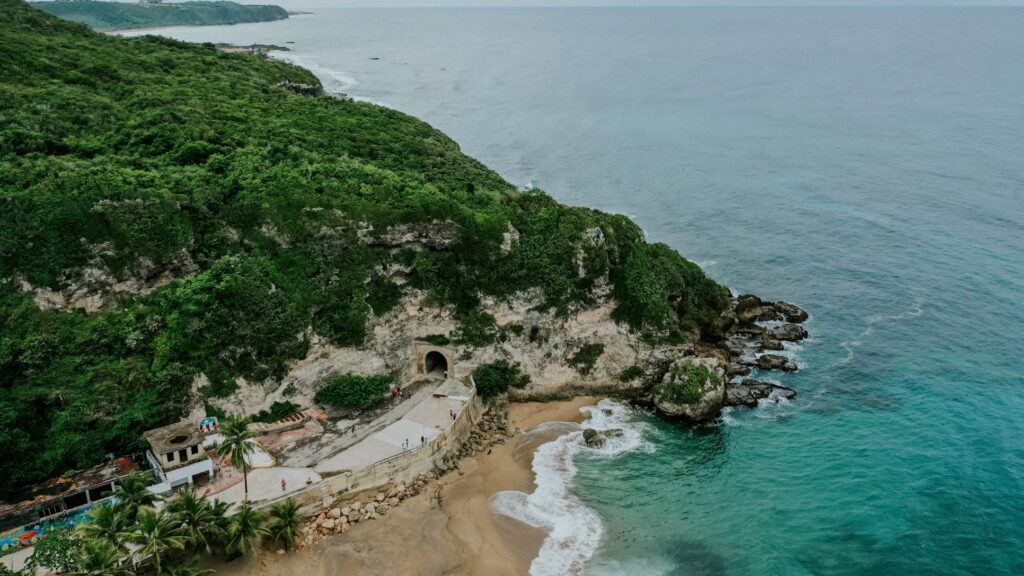 Coastal cliff edge and beach with the Cara del Indio rock carving. 