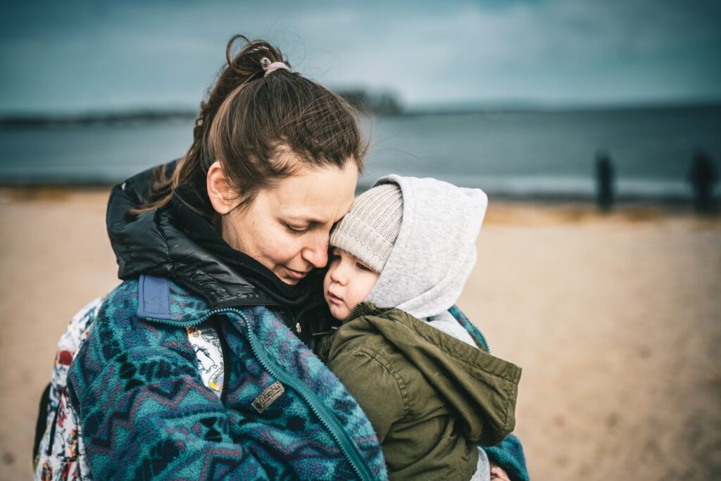 A mother comforting her tired toddler, illustrating the 'validate, don't fix' approach to managing emotions while traveling with kids