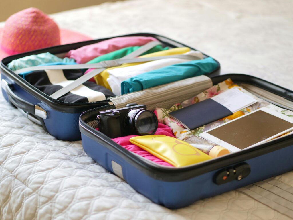 A neatly organized suitcase using the color-coded outfit rolling method, showcasing an efficient packing list for toddlers