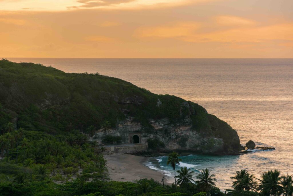 Things to Do in Puerto Rico: 23 Best Attractions, Beaches & Hidden Gems (2026) Golden sunset over a coastal cliff and hidden beach, one of the best things to do in Puerto Rico.