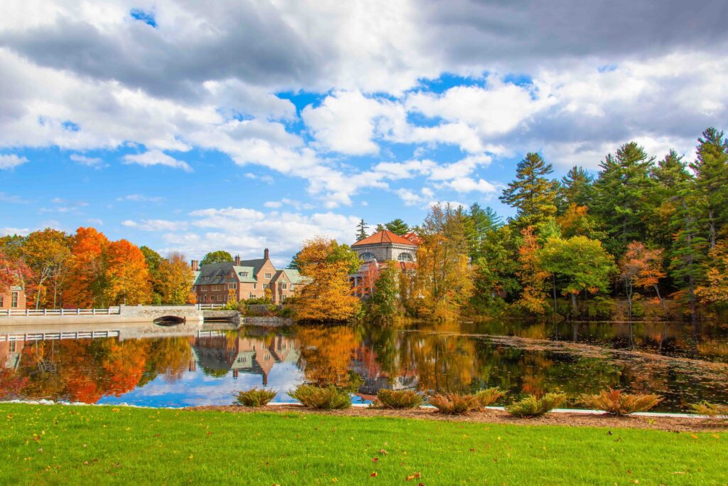 12 Best Places to Visit in November USA (2026): Cheap & Cozy Autumn foliage mirrored in a calm New England lake under blue sky, as one of the best places to visit in November USA.