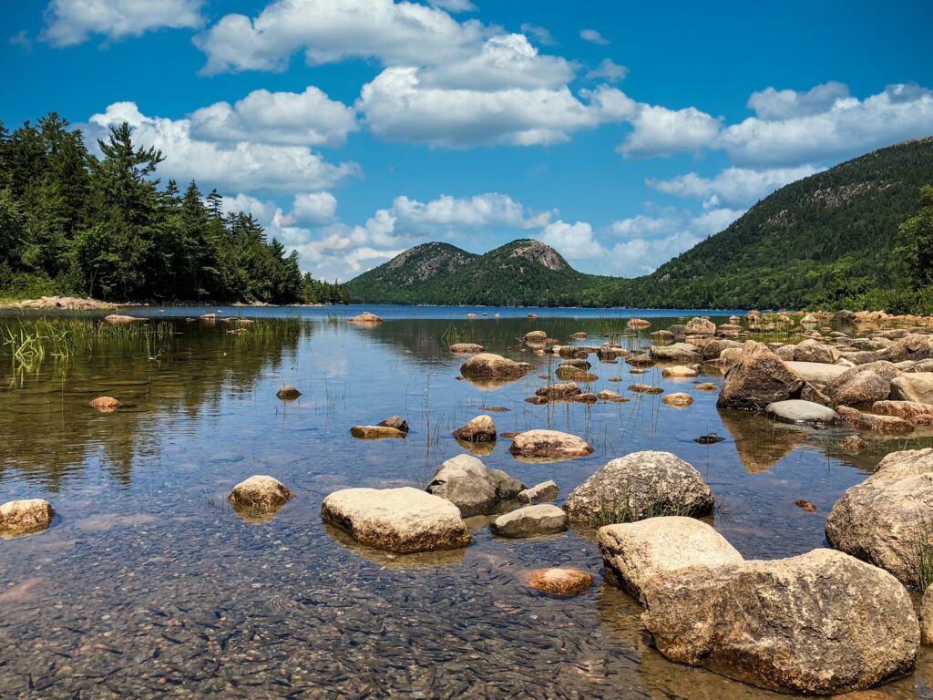 Large round rocks resting in the clear, shallow waters of Jordan Pond in Acadia National Park. 