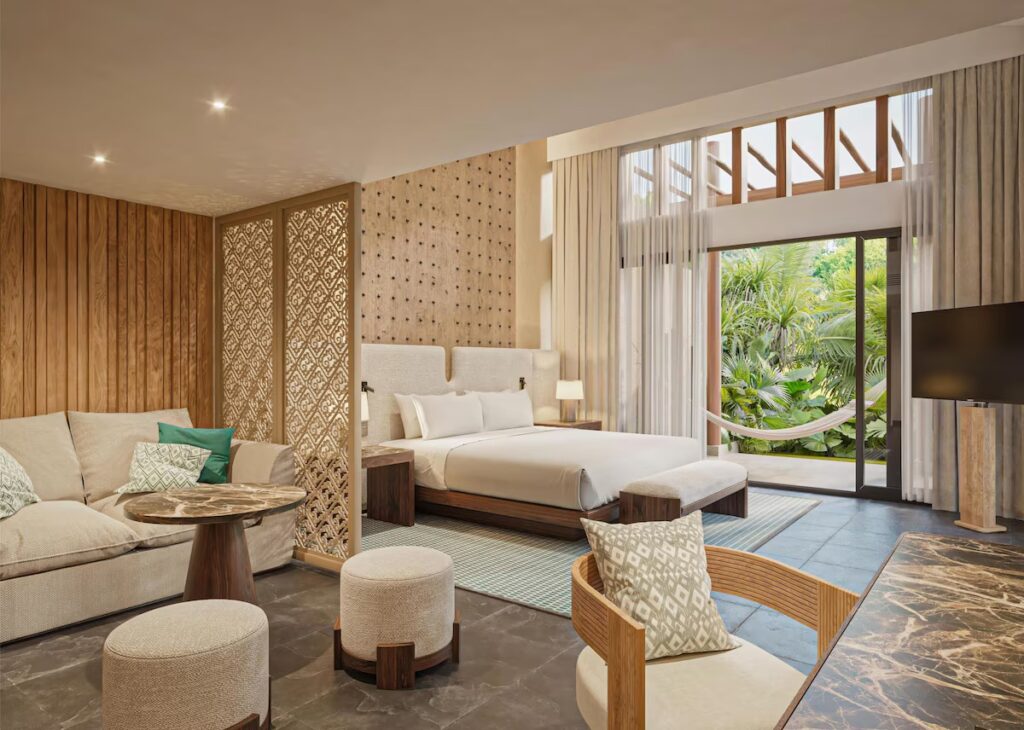 A modern bedroom suite featuring intricate wooden screens and direct outdoor access at Banyan Tree Mayakoba.