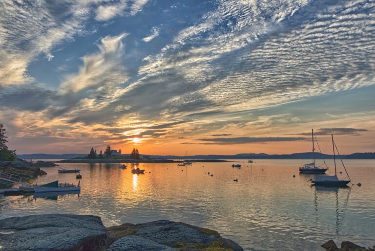The Best Time to Visit Maine (And the 2 Worst Months to Avoid in 2026) A scenic sunset over a calm harbor with sailboats, illustrating the best time to visit Maine.