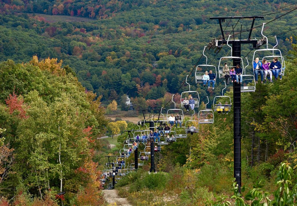 Chairlifts carrying passengers up the Camden Snow Bowl ski area during the vibrant autumn season.