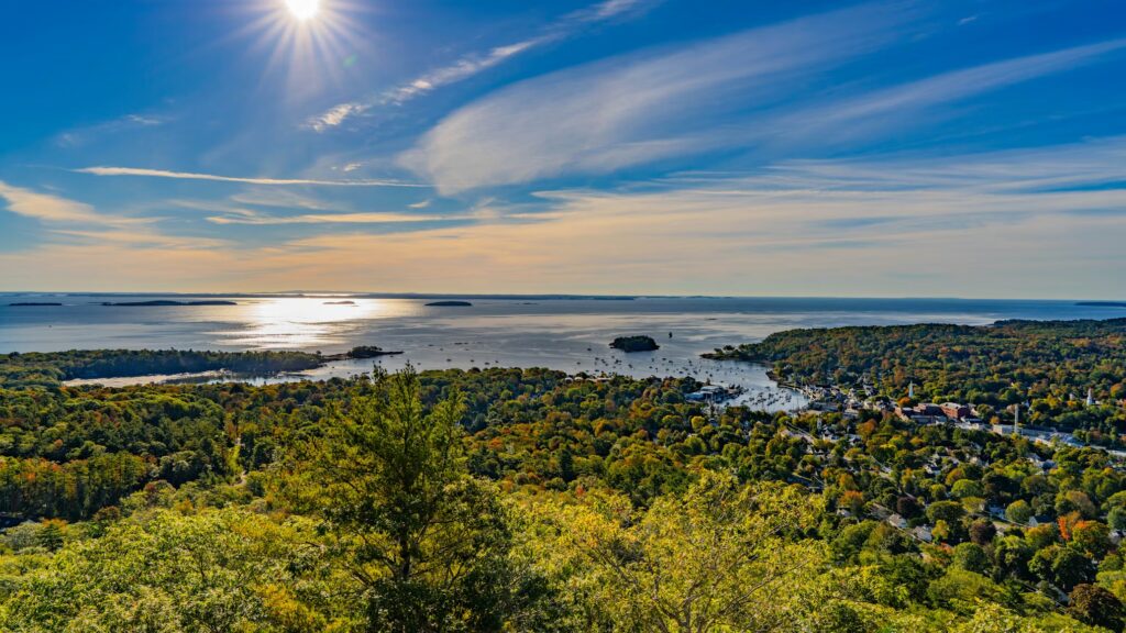 Panoramic view from a high vantage point overlooking a coastal town, harbor, and islands.