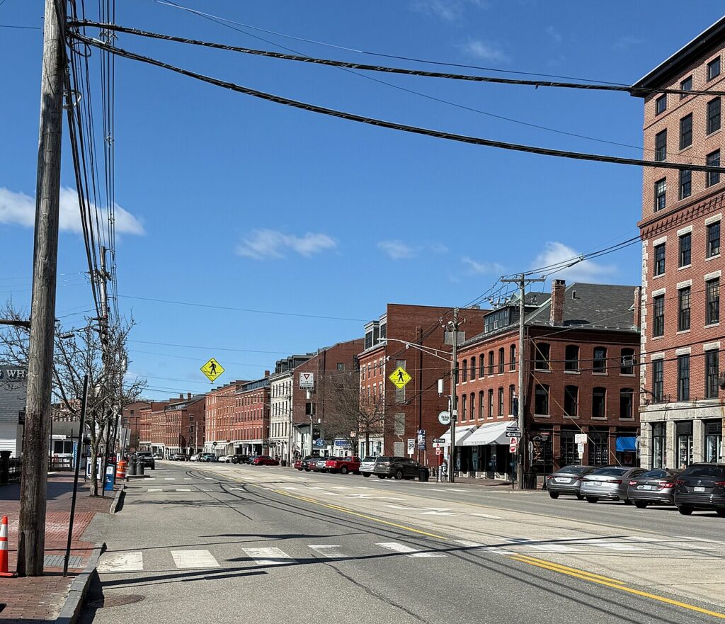 Historic brick buildings lining the wide, sunny Commercial Street in the Old Port district. 