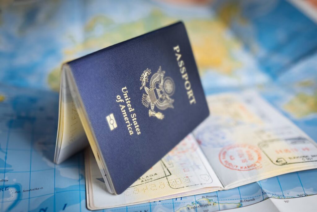 A US passport book opened on a map, which is the essential document for air travel to Mexico.
