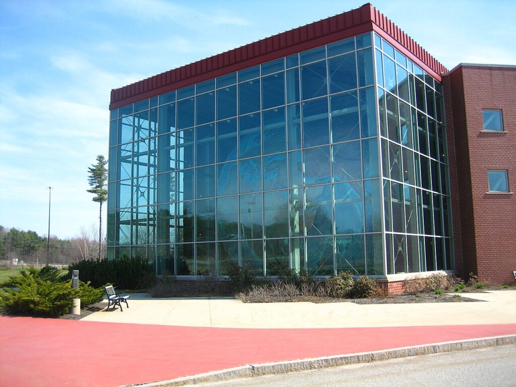 A massive, multi-story glass atrium building housing Eartha, the world's largest rotating globe.