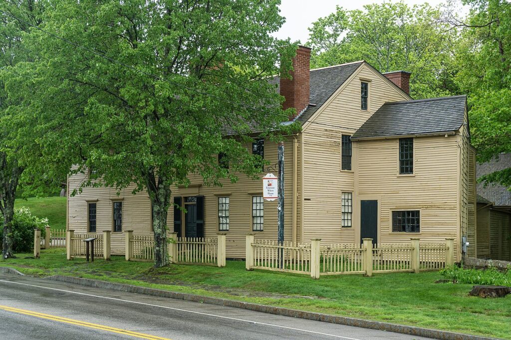 The historic yellow wood-paneled exterior of the Emerson-Wilcox House in the colonial historic district of York Village.