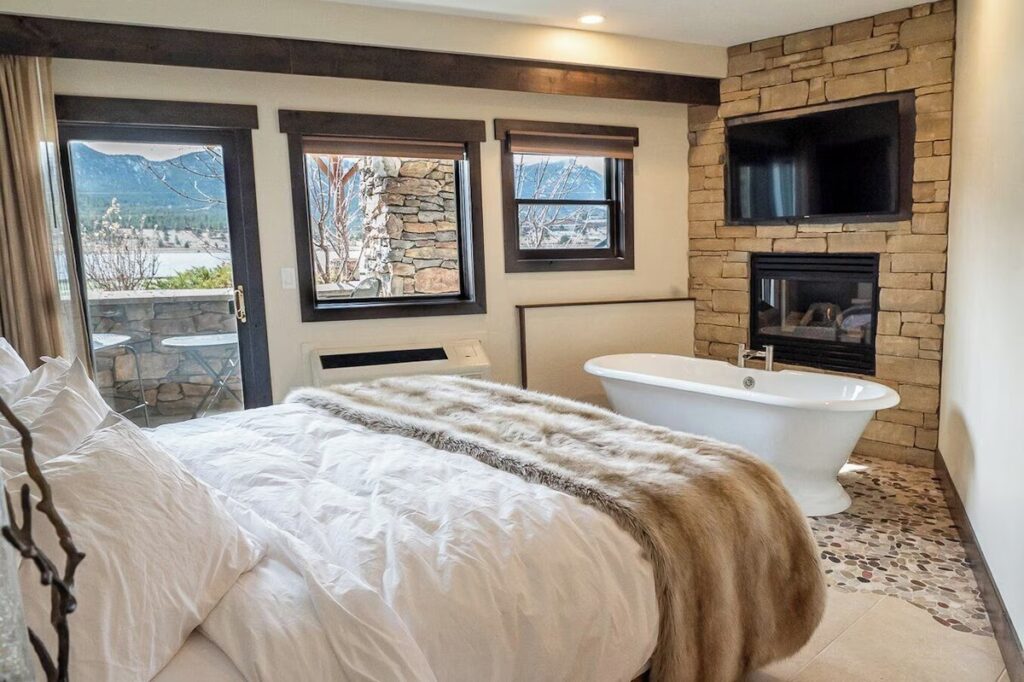 Bedroom featuring a freestanding bathtub and fireplace at The Estes Park Resort in Estes Park. 